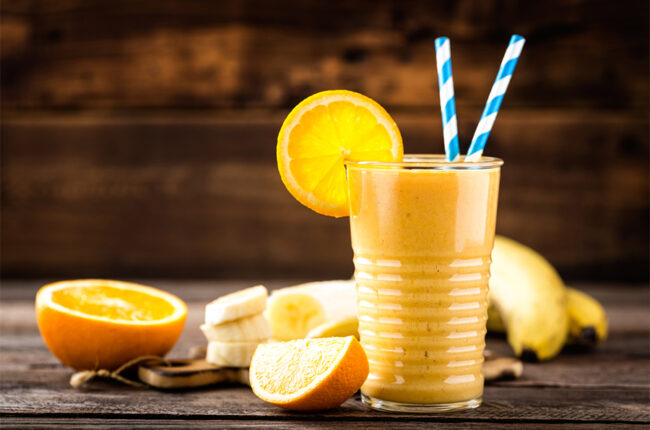 Glass of Mango Orange Creamsicle Smoothie with orange slice garnish