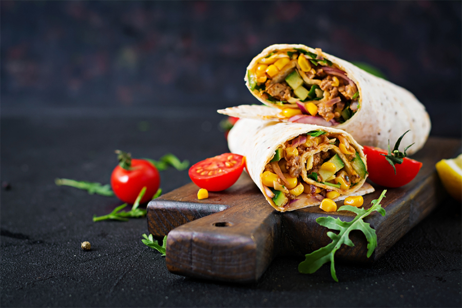 Two burritos on a cutting board