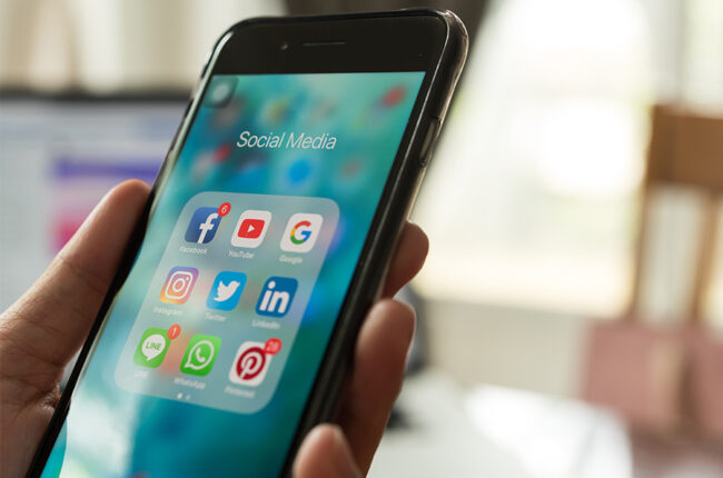 Close up of an iphone with social media folder and social media apps