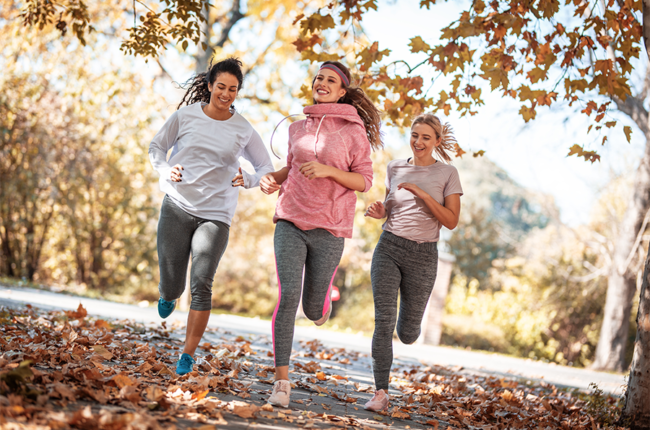 Group of women running in a park during fall