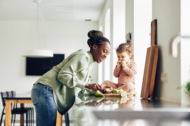 Mother and daughter preparing fruit for snack time