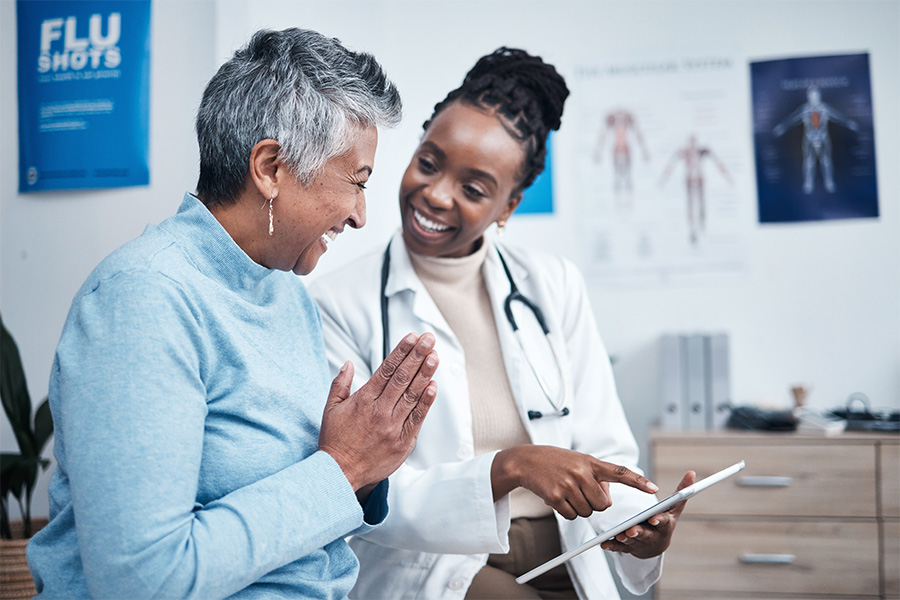 Middle-aged woman happily discussing with her doctor at medical appointment